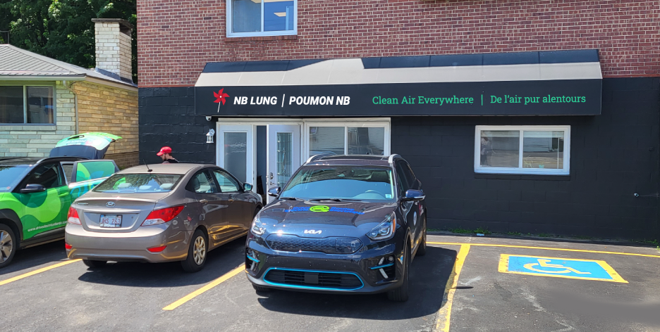 Image of NB Lung's new office location at 132 Main Street in Fredericton. Three cars are parked next to an accessible parking spot.